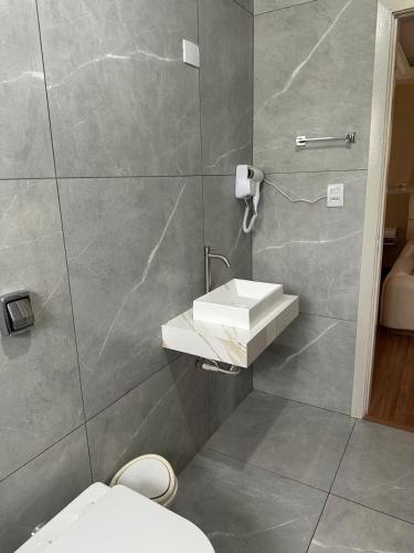 a bathroom with a sink and a toilet at Johnnys motel hotel in Jacarèzinho