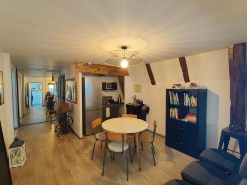 a living room with a table and a kitchen at Maison d'Hôtes La Grange in Salers