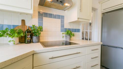 a kitchen with white cabinets and a sink at Borth Mawr in Rhosneigr