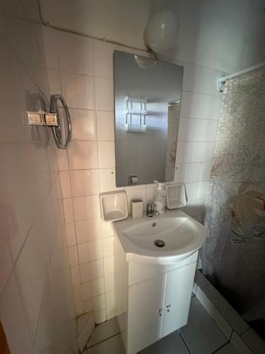 a white bathroom with a sink and a mirror at Luxury Beach House 2 in Xiropigado