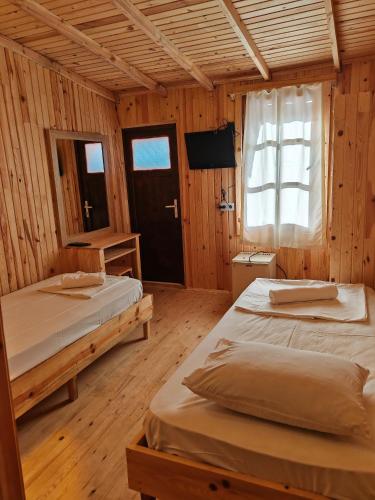 ein Schlafzimmer mit zwei Betten, einem Fenster und einem Fernseher in der Unterkunft Ünal Boutique Hotel in Kemer
