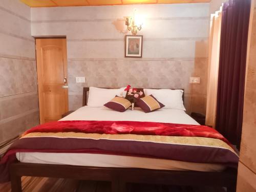 a bedroom with a bed with a red blanket at Royal Green Buds - Near Chamunda Devi Temple in Pathyar