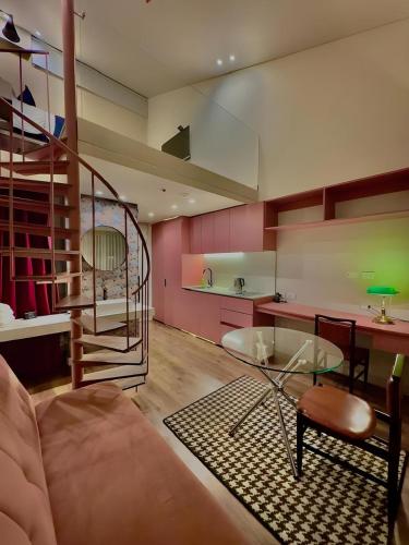 a living room with a couch and a spiral staircase at Grace Chapinero in Bogotá