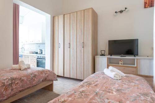 a bedroom with a bed and a tv and a cabinet at Blue horizont in Mlini
