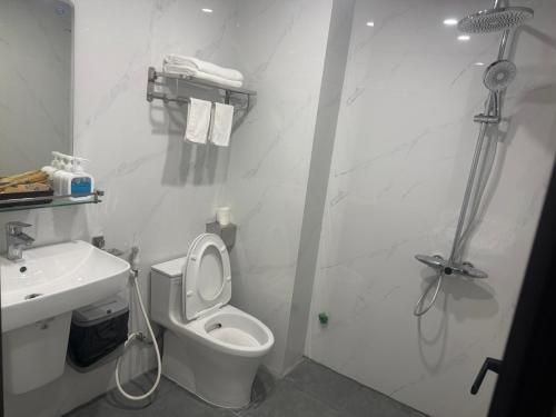 a white bathroom with a toilet and a sink at Anh Nhiên Hotel in Ninh Binh