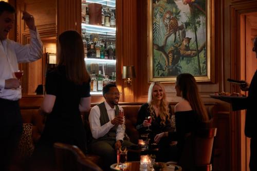 a group of people sitting in a bar at Rubens At The Palace in London