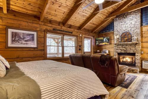 a bedroom with a bed and a fireplace in a log cabin at Honeymoon Sweet in Townsend