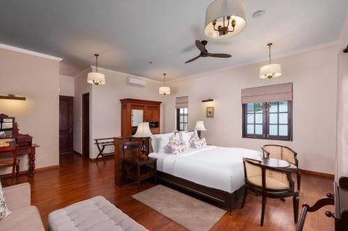 a bedroom with a white bed and a couch at Chimneys Nuwara Eliya in Nuwara Eliya