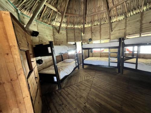 a room with three bunk beds in a hut at Casa en el agua in Tintipan Island