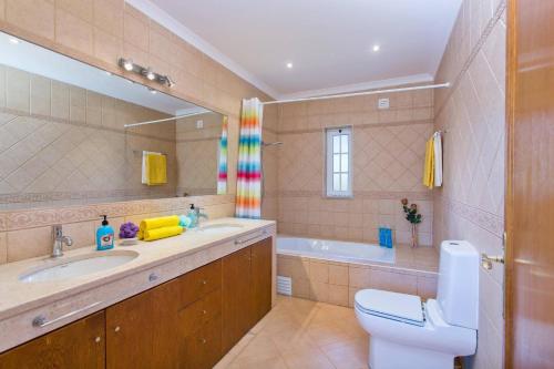 a bathroom with a sink and a toilet and a tub at Villa Teotel by Villa Plus in Almancil