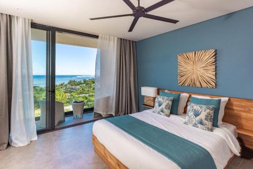 a bedroom with a bed with blue walls and a large window at Panoramic View Mauritius in Ruisseau Créole