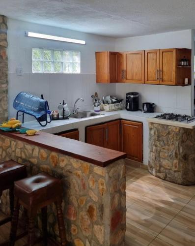 a kitchen with wooden cabinets and a stone counter top at Gaia - Casa de Playa in San Bernardo del Viento