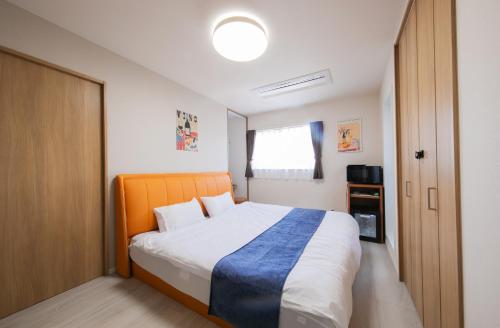 ein Schlafzimmer mit einem Bett, auf dem eine blaue Decke liegt in der Unterkunft Trattoria&BarTroppo in Hayaki