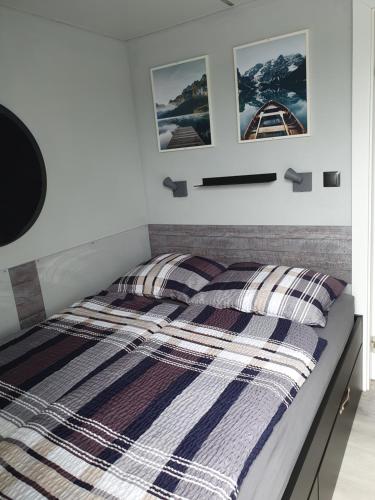 a bedroom with a bed with striped comforter at Hausboot Lucky in Hattem