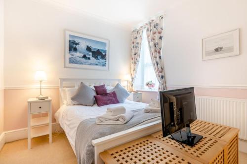 a small bedroom with a bed with a television at 2 Bed in Woolacombe oc-dolph in Woolacombe