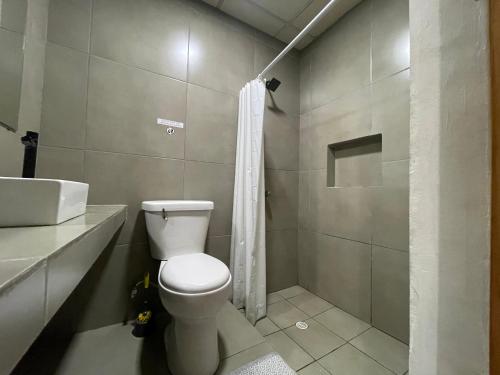 a bathroom with a toilet and a shower and a sink at OyeBonita Hostel in Panama City