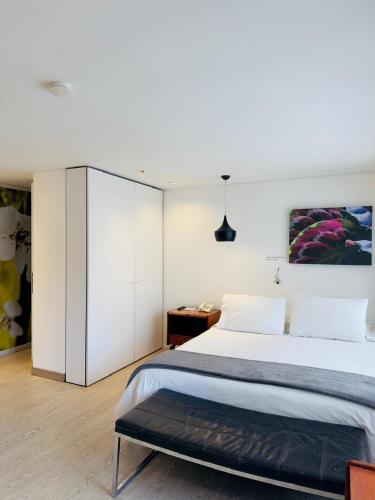 a bedroom with a large bed and a desk at The Grace Hotel in Bogotá