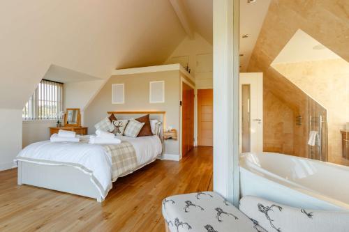 a bedroom with a large bed and a bath tub at Taigh Gleusta in Angus