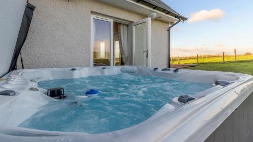 a hot tub in the backyard of a house at Taigh Gleusta in Angus