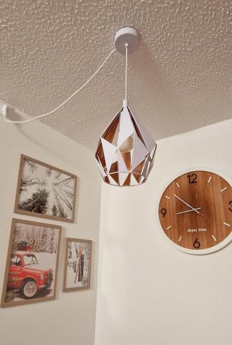 a clock on a wall next to a chandelier at Il Cuore del Tonale in Passo del Tonale