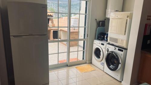 a kitchen with a washing machine and a window at Maribel's Place in Funchal