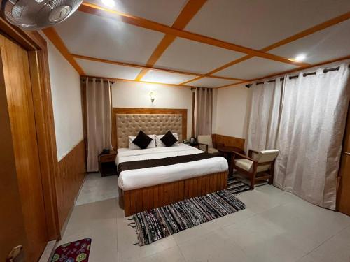 a hotel room with a bed and a table and chair at Hexon Stays in Manāli