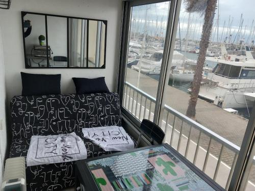 a balcony with a couch and a view of a marina at studio cabine tous cocooning in Gruissan