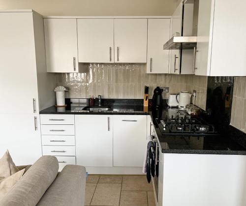 a kitchen with white cabinets and a stove top oven at Windsor Mews by Stay Focused SA in Windsor