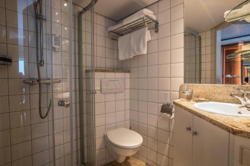 a bathroom with a shower and a toilet and a sink at VIVA RIVERSIDE Messe Düsseldorf in Düsseldorf