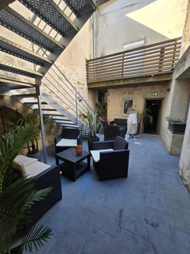 a patio with couches and tables in a building at B&B Le MONSEG 33 in Monségur