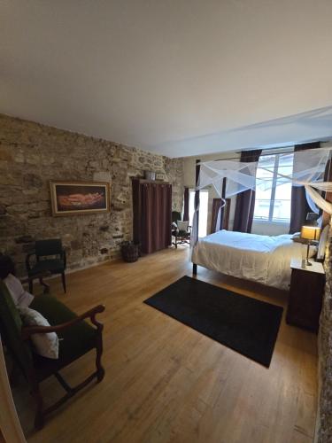 a bedroom with a bed and a chair in a room at B&B Le MONSEG 33 in Monségur