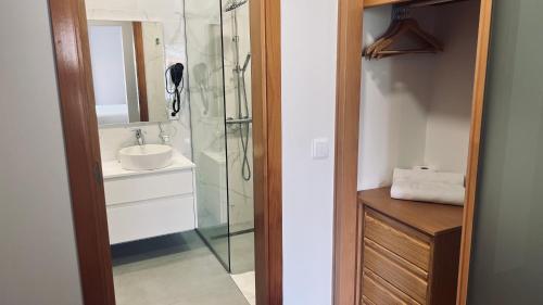 a bathroom with a glass shower and a sink at Maribel's Place in Funchal