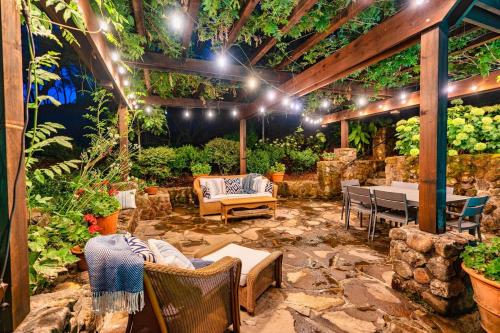 a patio with chairs and tables and plants at Morlet Hilltop House in St. Helena
