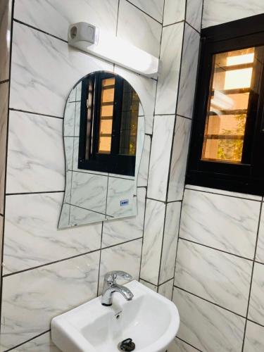a bathroom with a sink and a mirror at KMC Guest House in Douala
