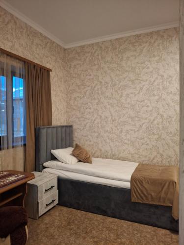 a bedroom with a large bed and a desk at Tatev 1 in Tatʼev