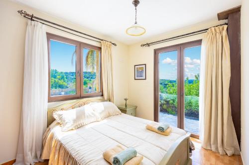 a bedroom with a bed and a large window at Villa Alonia in Simou