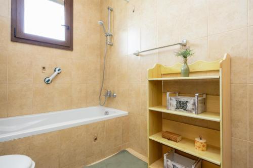 a bathroom with a tub and a toilet and a sink at Villa Alonia in Simou