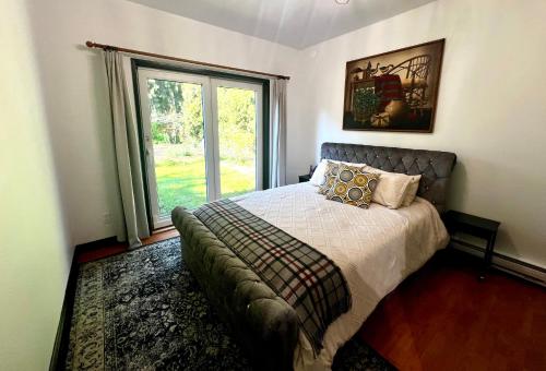 a bedroom with a bed and a large window at The Family Cottage in Delta