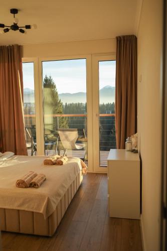 a bedroom with a bed and a view of a balcony at Sunrise Yablunytsia in Yablunytsya