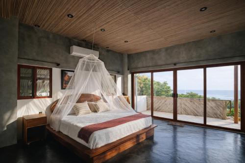 a bedroom with a bed with a mosquito net at Casa Moorea - Steps to Beach in Puerto Escondido