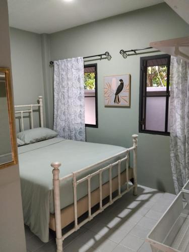 a bedroom with a bed and two windows at Villa La Origin Life in Phuket