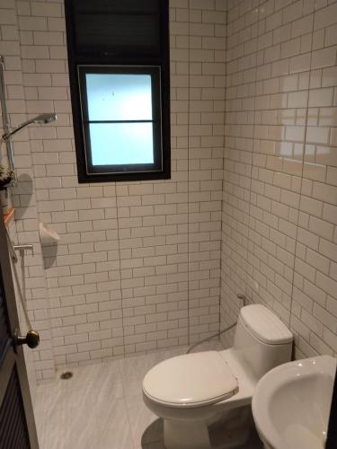 a white bathroom with a toilet and a window at Villa La Origin Life in Phuket