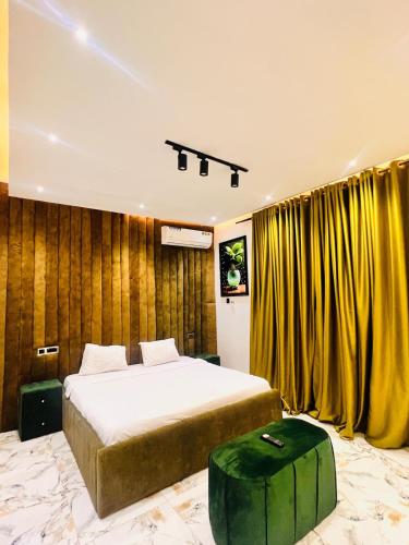 a bedroom with a large bed and yellow curtains at 3BED flat close to the airport lagos in Lagos