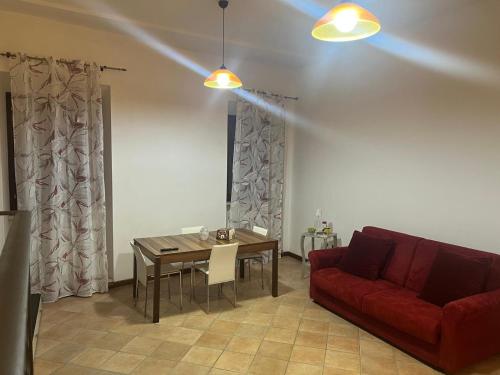 a living room with a red couch and a table at La Petite Maison Rieti in Rieti
