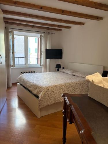 a bedroom with a large bed and a window at Casa Polly in Rovereto