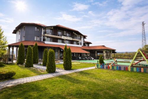 a building with a playground in front of a park at Maribel Spa Hotel in Köprilova