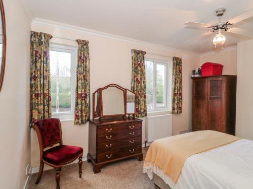 a bedroom with a bed and a mirror and a chair at The Flat House in Taunton