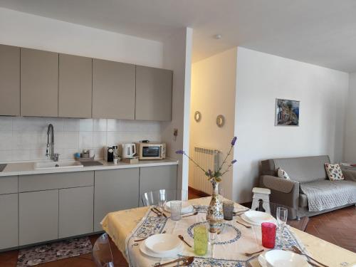 a kitchen with a table and a couch in a room at La Casa di Giada, appartamento a piano terra con aria condizionata, wi-fi e parcheggio gratuito in Poggi
