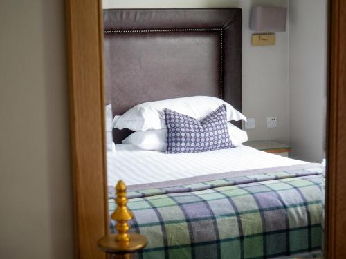 a reflection of a bed with pillows in a mirror at Elmers Court in Lymington