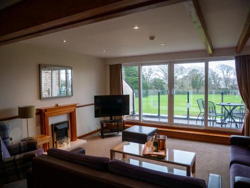 a living room with a fireplace and a tv at Elmers Court in Lymington